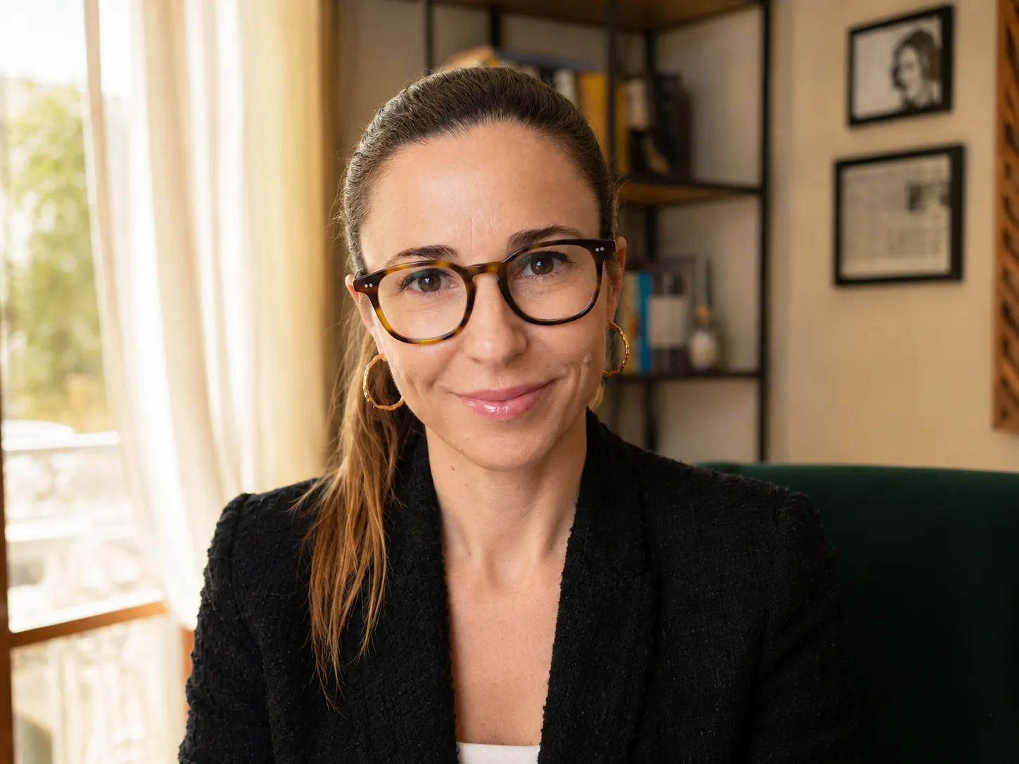 Ritratto della Dott.ssa Laura Castaldo seduta nel suo studio a Napoli, con finestra e libreria sullo sfondo.